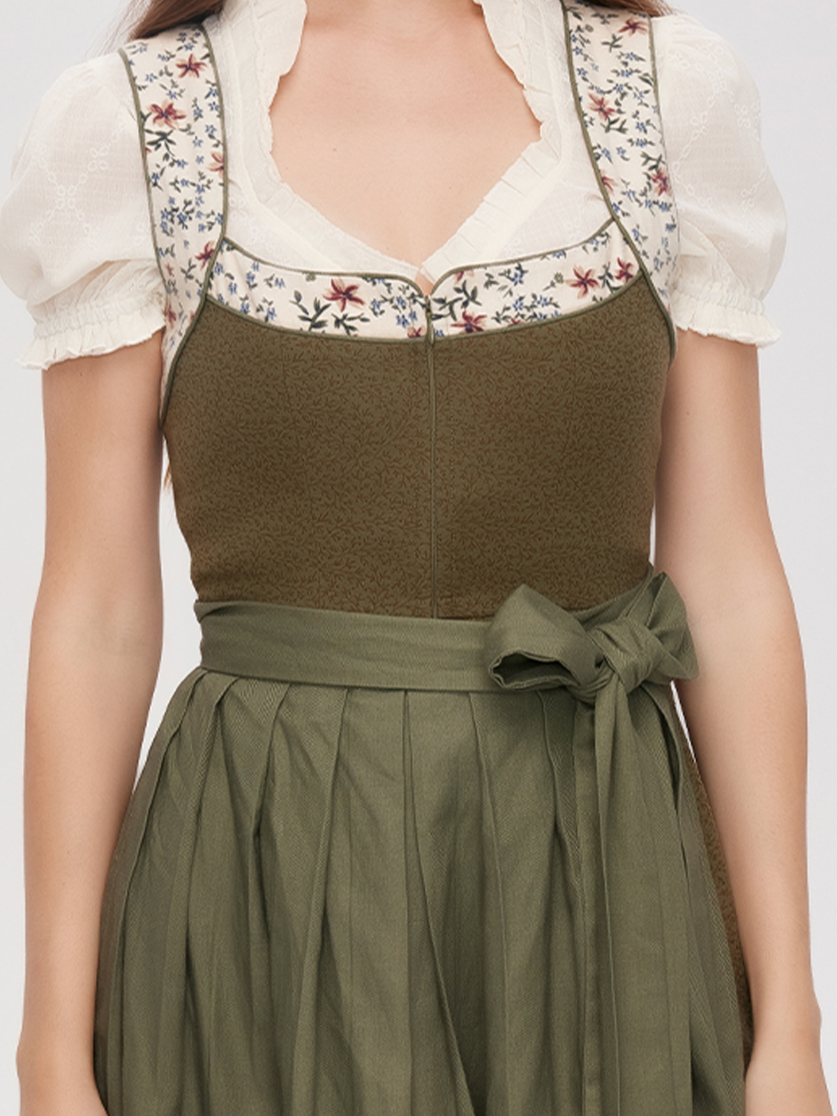 Ein grünes Dirndl mit floralen Akzenten – perfekt für Schwangere