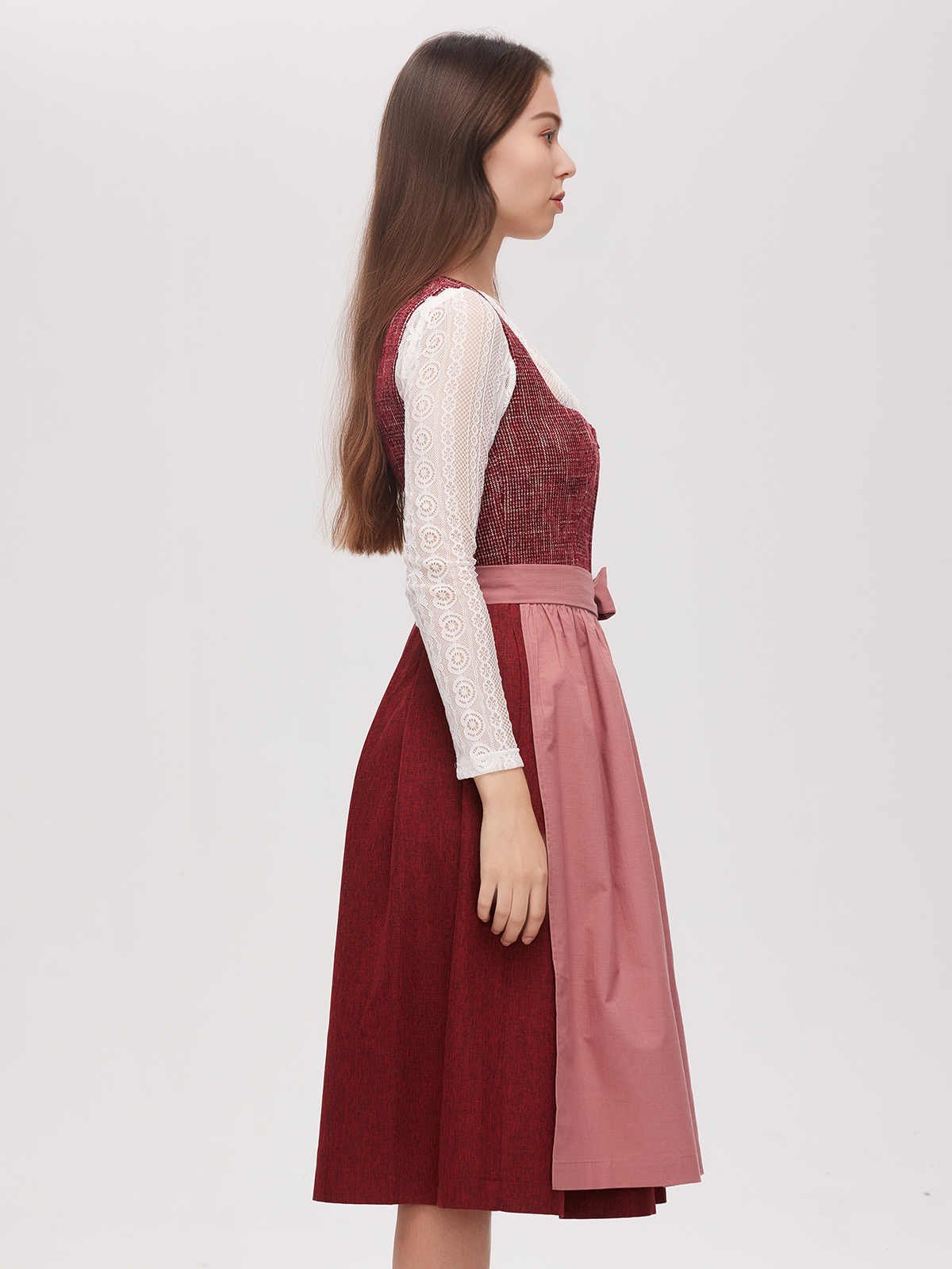 Frau in rotem Dirndl mit langärmliger Bluse
